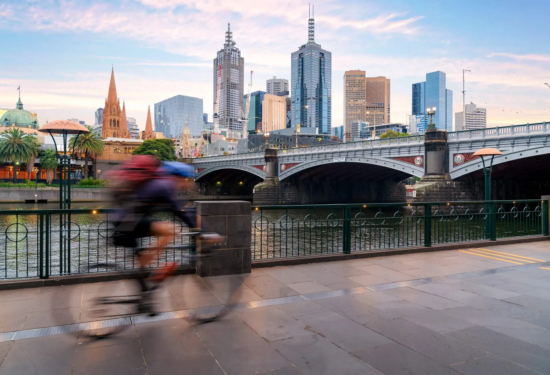 Australian people cycling for exercise near Yarra River with view of the Melbourne City Financial District with skyscrapers in morning at Melbourne, Victoria, Australia.