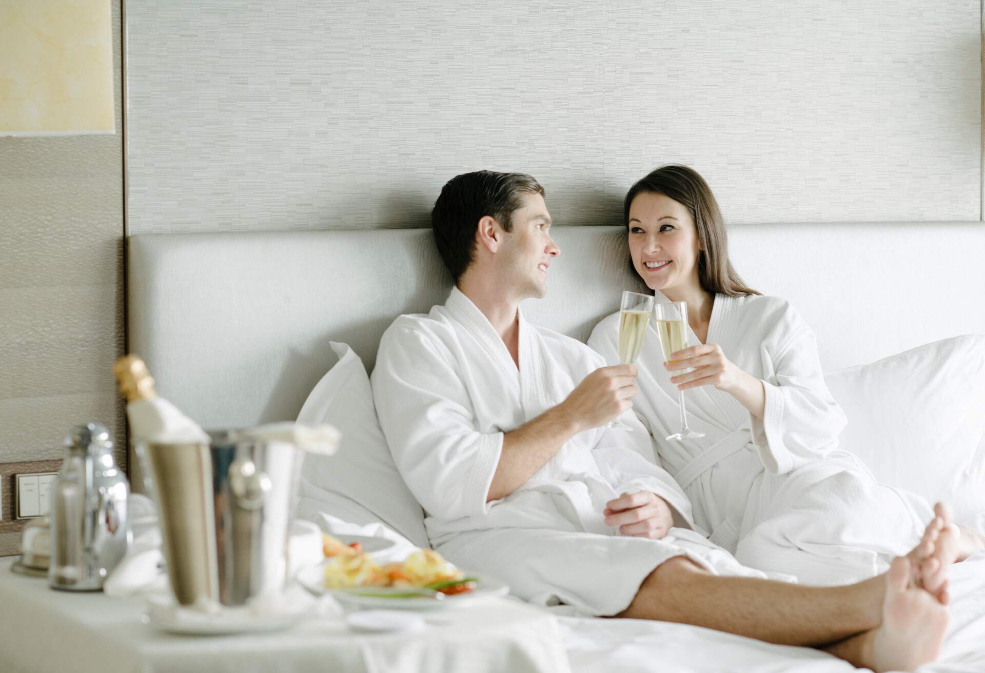 PEOPLE_COUPLE_CELEBRATING_HOTEL_ROOM_CHAMPAGNE_DRINKING