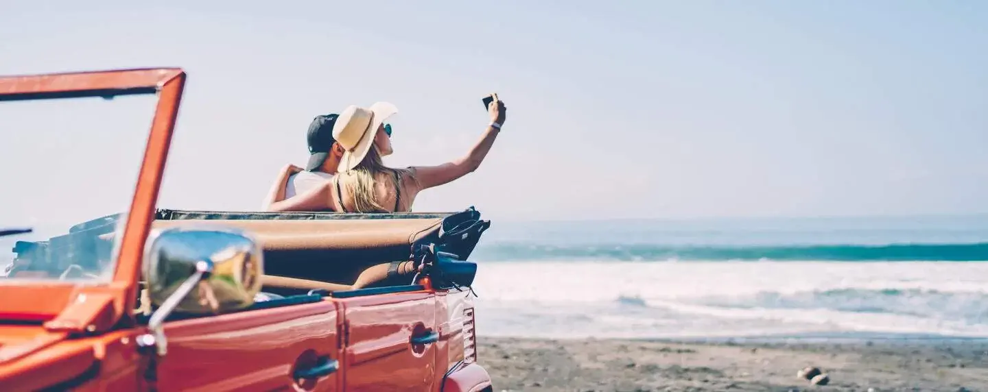 THEME_ROAD-TRIP_BEACH_COUPLE_CONVERTIBLE_Shutterstock