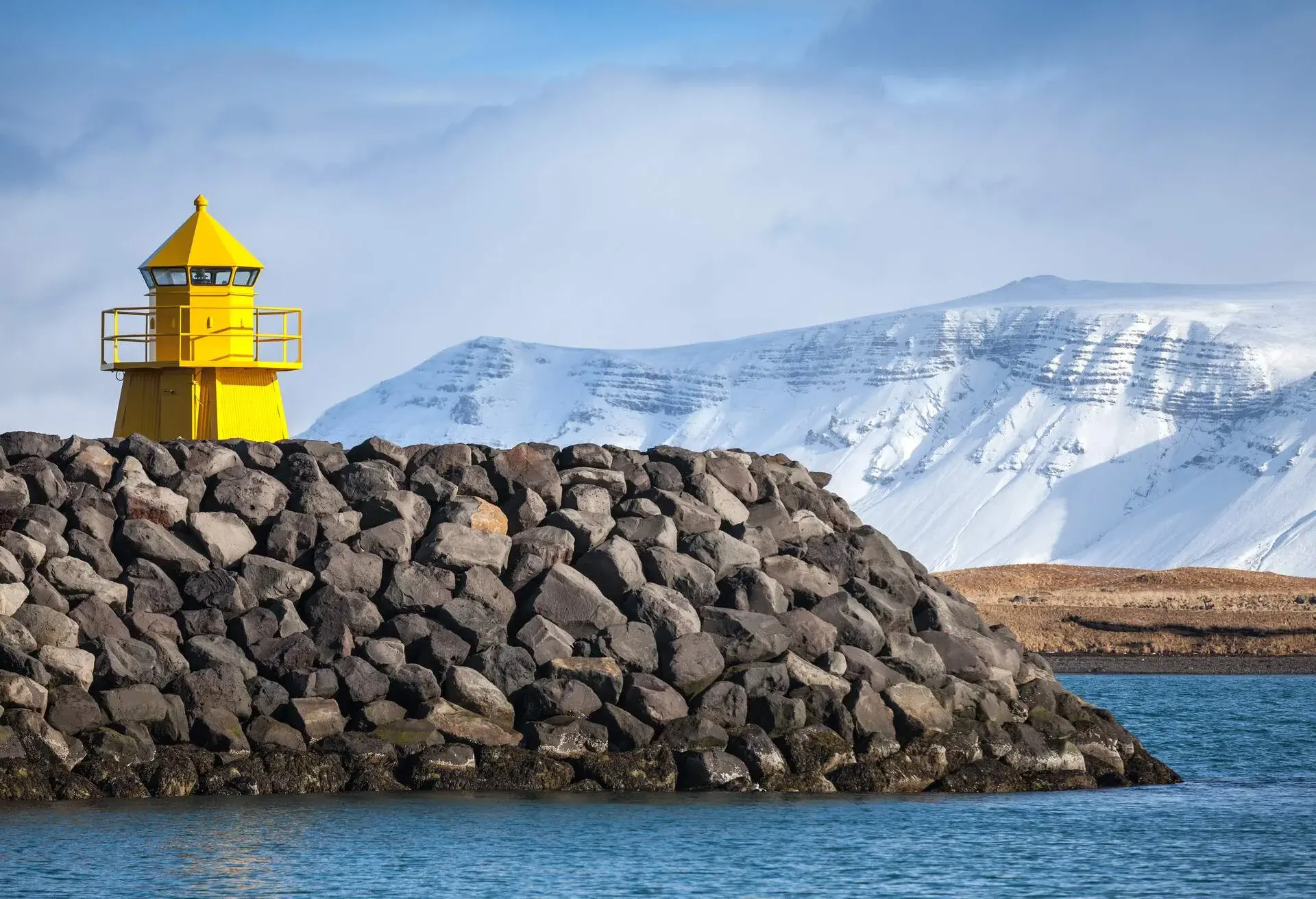 Yellow lighthouse tower on stone breakwater, entrance to Reykjavik port; Shutterstock ID 618389888; Purpose: Twitter; Brand (KAYAK, Momondo, Any): KAYAK